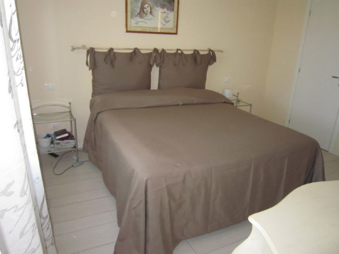 bastone da tenda usato come testata del letto e copriletto su misura