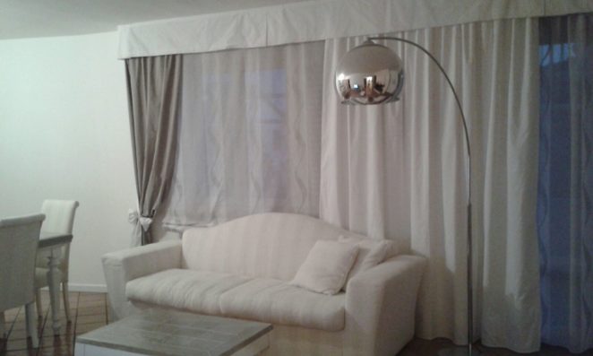 tende a pacchetto e classiche per sala su binari e con mantovana bianca e fiocco fermatenda