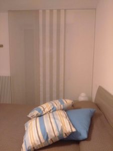 cuscini e copriletti coordinati con tende a pannello in lino