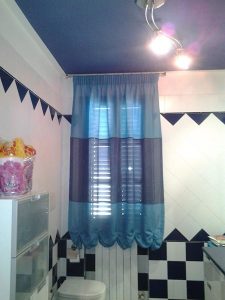 tenda a finto pacchetto in tessuto azzurro e grigio per finestra del bagno