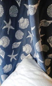 stoffa da interni coastal con conchiglie e stelle marine su fondo blu