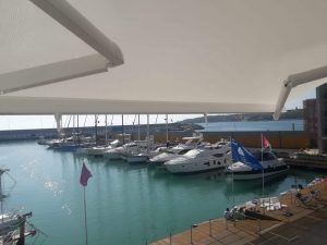 tenda a bracci motorizzata e con barra quadra in alluminio nel porto di cala de' medici