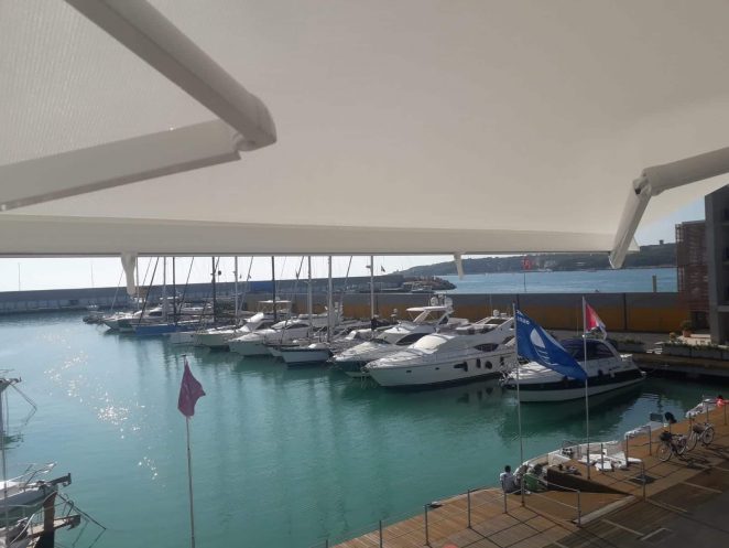 tende da sole a bracci estensibili motorizzate e con barra quadra in alluminio nel porto di cala de' medici