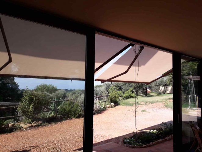 tende a bracci in microforato con struttura color ruggine e con motore e sensore vento