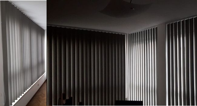 tende a strisce verticali in tessuto filtrante per ampio studio di appartamento