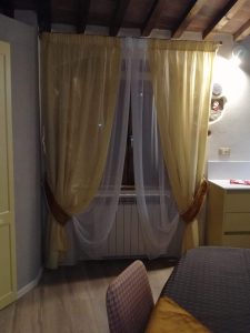 tende in velo giallo e bianco su bastone per finestra della cucina